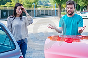 Two drivers arguing about damage to their cars after accident