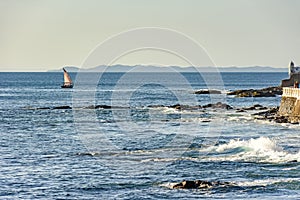Rudimentary fishing boat sailing on the horizon during sunset in All Saints Bay photo