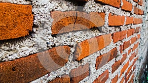 A rudimentary wall of red bricks and cement ... photo