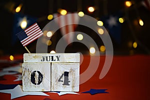 Ruffled American flag and wooden cube calendar with 4th of July, USA Independence Day date, copy space celebratory background. US