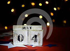 Ruffled American flag and wooden cube calendar with 4th of July, USA Independence Day date, copy space celebratory background. US