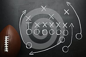 Rugby ball and drawn American football game on black chalkboard, top view