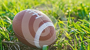 Rugby ball on green grass, american football.