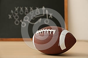 Rugby ball near chalkboard with football game scheme