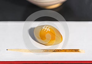 Rugby ball shaped Japanese confection called wagashi or namagashi and a kuromoji skewer.