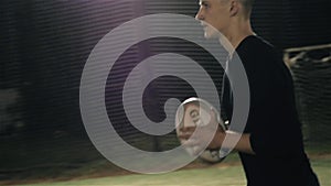 Rugby fan player in arena against rugby players training with ball, dark football arena