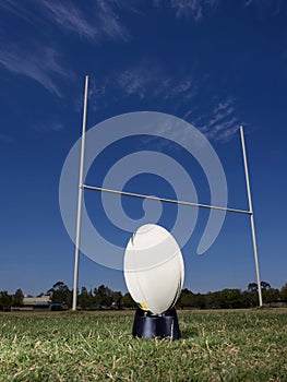 Rugby football positioned in front of the goal posts.
