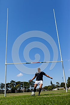 Rugby player making goal on grassy field