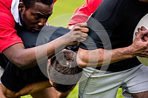 Rugby players tackling during game