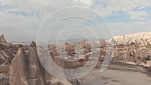 Rugged barren landscape dotted with fairy chimneys, conned rock like structures in Cappadocia, Turkey