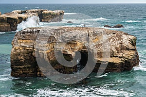 The rugged beauty of a rocky coastline meeting the vast expanse of the ocean under a dramatic sky, California