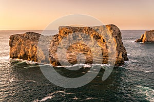 Rugged cliffs of the coastline of Cape St. Vincent at sunset. Near Lagos, Algarve region of Portugal.