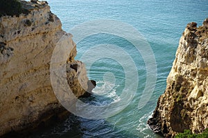 Rugged cliffs of Marinha Beach in Portugal surrounded by turquoise water