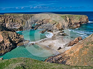 The rugged coastal cliff scenery and pristine turquoise waters around the island of Uyea in Northmavine, Shetland, UK.