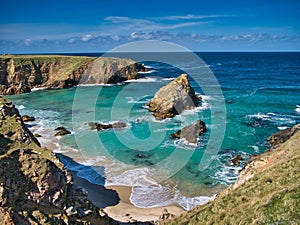 The rugged coastal cliff scenery and pristine turquoise waters around the island of Uyea in Northmavine, Shetland, UK.