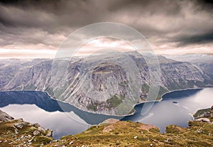 Rugged dramatic mountain landscape in norway cloudy dramatic day with calm lake