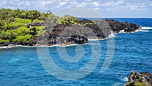 Rugged lava shoreline next to the Black sand beach on the Island of Maui in the State of Hawaii.