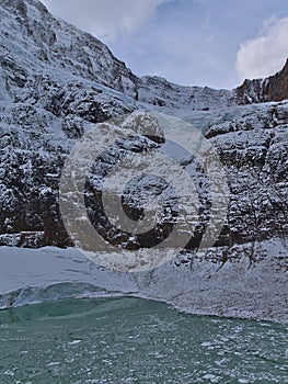 Rugged Mount Edith Cavell in late autumn with Angel Glacier and glacial lake with ice floes in Jasper National Park, Canada.