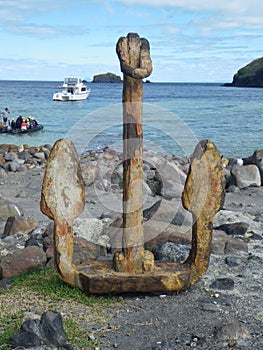 Ruin of anchor on White Island in New Zealand with tourist boat in the background