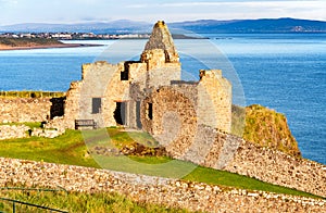 Ruin of Dunluce castle and Portrush in Northern Ireland photo