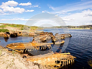 Ruin of old wooden sunken fishing boats in Teriberka, Murmansk Oblast, Russia