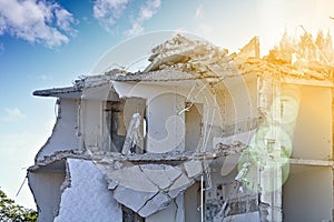 Ruin of a partly demolished residential building upper floor, sunlit with lens flare