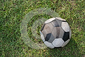 Ruin soccer ball or football on green grass by top view