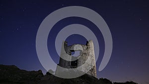 Ruin windmill in the night sky. startrails timelapse.