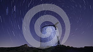 Ruin windmill in the night sky. startrails timelapse.