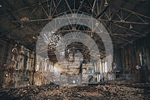 Ruined and abandoned dark creepy factory house building inside, industrial warehouse hall waiting for demolition