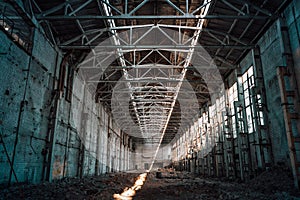 Ruined and abandoned industrial factory warehouse hangar with perspective view