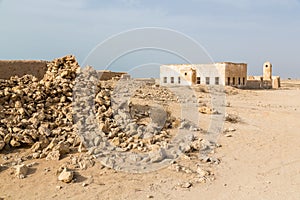 Ruined ancient old Arab pearling and fishing town Al Jumail, Qatar. The desert at coast of Persian Gulf. Pile of stones.