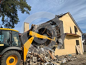 Ruined, brick, residential building. The ruins of a collapsed mansion in the forest. Demolition of an old house with an excavator