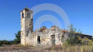 A ruined church its bell tower leaning to one side and its walls marred by deep cracks