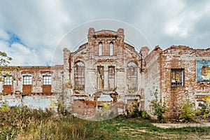 Ruined facade of red brick industrial building in art nouveau style.