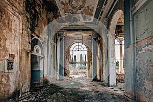 Ruined large hall interior overgrown by plants and moss