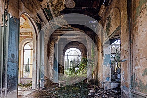 Ruined large hall interior overgrown by plants and moss