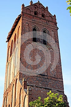 ruined old catholic church made of red brick against the blue sky