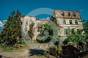 Ruined overgrown hospital in ghost mining town Akarmara, consequences of war in Abkhazia, green post-apocalyptic concept