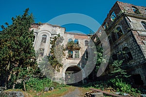 Ruined overgrown hospital in ghost mining town Akarmara, consequences of war in Abkhazia, green post-apocalyptic concept