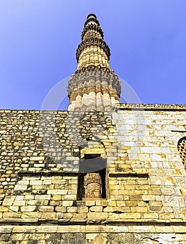 Ruined Quwwat ul-Islam Mosque with Qutb Minar tower in background at Qutub Minar complex