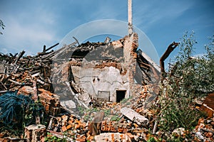 Ruined red brick building destroyed by earthquake or tornado or war or other disaster. Demolished house. Debris, garbage