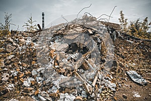 Ruined red brick building destroyed by earthquake or tornado or war or other disaster. Demolished house. Debris, garbage and trash