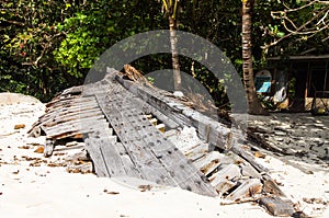 Ruined skeleton of an old boat on the shore of a tropical island