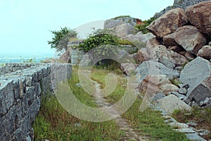 Ruined stone wall with a sand path