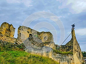 Ruined Valkenburg Castle on hill against cloud-covered blue sky