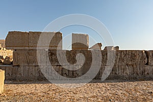 Ruined wall with bas reliefs at northern facade of Palace of Artaxerxes in Persepolis