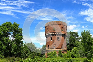 Ruined water tower made of red bricks with windows