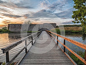 Ruins of ancient castle with bridge in front at sunset time