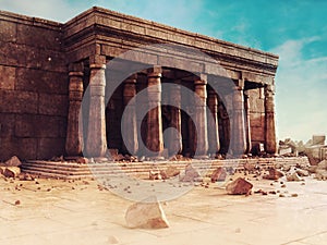 Ruins of an ancient Egyptian temple including a wall, columns and stone statues